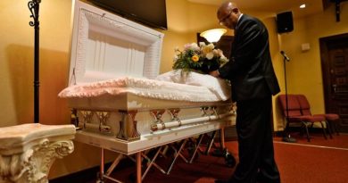 Associated Press | El director de la funeraria arregla flores en un ataúd antes de un servicio